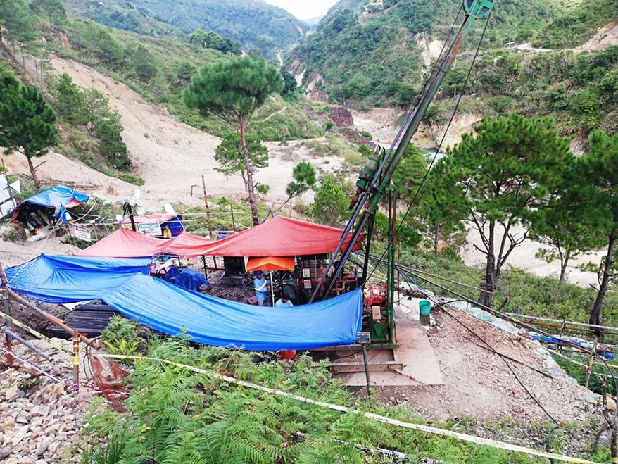 MEGA Philippines crew working with a drilling rig and geophysical logging equipment at a mountain project site