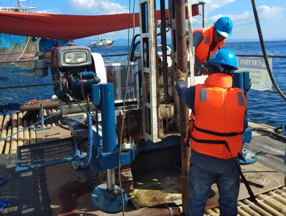 MEGA Philippines crew operating a drilling rig on a floating platform for proposed port facilities